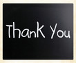 "Thank you" handwritten with white chalk on a blackboard