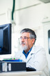 Senior researcher working on a computer in a lab Senior researcher working on a computer in a lab