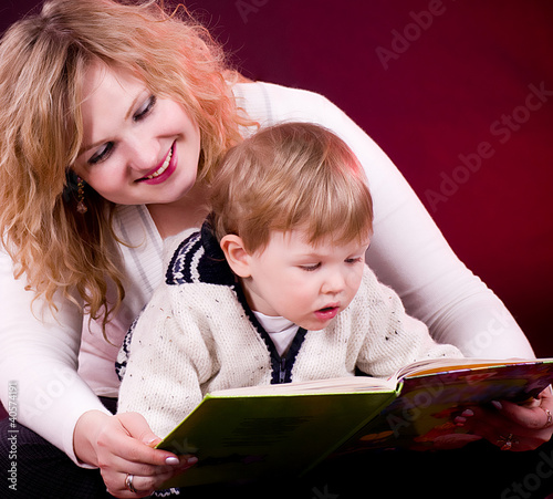 Photo: Mother and baby boy reading book and smiling Mother and baby boy reading book and smiling