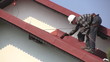 Man paints roof of a private house
