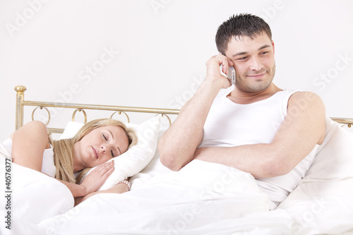 Photo: man cheating while woman sleeping man cheating while woman sleeping