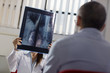 Photo: Female doctor working in hospital with patient and x-rays Female doctor working in hospital with patient and x-rays