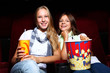 Two young girls watching in cinema