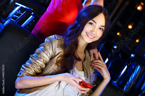 Photo: Attractive woman in night club with a drink Attractive woman in night club with a drink