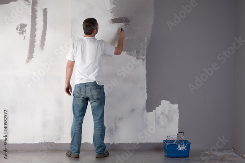 Photo: Man painting a wall. Man painting a wall.