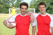 friends playing football posing together