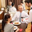 Business lunch waiter serving red wine