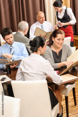 Photo: Business lunch executives look menu restaurant Business lunch executives look menu restaurant