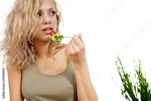 Photo: Portrait of young happy smiling woman eating salad Portrait of young happy smiling woman eating salad