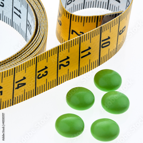 Foto: Maßband und Tabletten, als Symbol für Diätpillen Maßband und Tabletten, als Symbol für Diätpillen