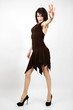 Young woman in brown dress making stop gesture.