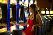 Photo: Young woman playing with slot machines Young woman playing with slot machines