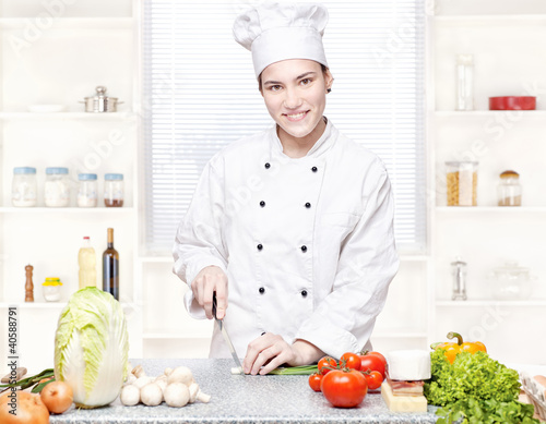 Photo: Young chef cutting onions in kitchen Young chef cutting onions in kitchen