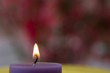 A purple candle in front of pink backround A purple candle in front of pink backround