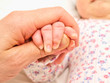Parent holding an infants hand