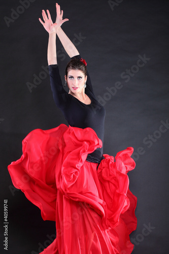 Foto: Attractive spanish young woman dancing flamenco over black backg Attractive spanish young woman dancing flamenco over black backg