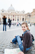 Pretty young female tourist studying a map at St. Peter's square