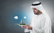 Photo: arabian businessman with a virtual city presentation on a pad arabian businessman with a virtual city presentation on a pad