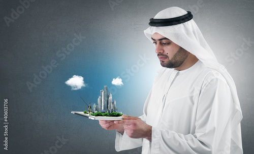 Photo: arabian businessman with a virtual city presentation on a pad arabian businessman with a virtual city presentation on a pad