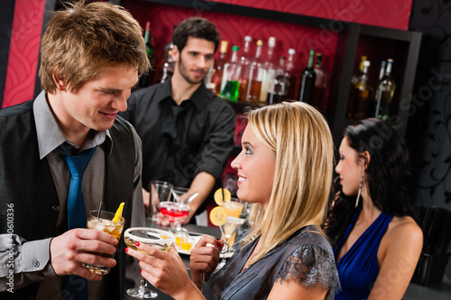 Photo: Happy friends at cocktail bar enjoy drinks Happy friends at cocktail bar enjoy drinks