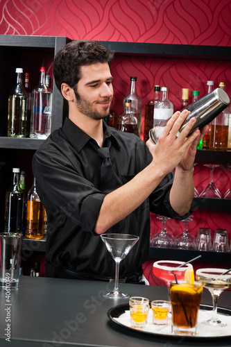 Photo: Young bartender make cocktail shaking drinks Young bartender make cocktail shaking drinks