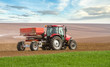 an agricultural tractor starts a chemical treatment