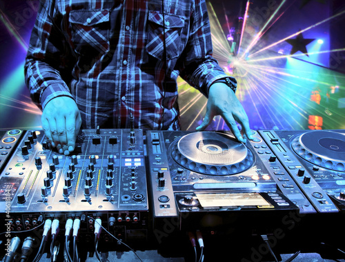 Foto: Dj mixes the track in nightclub at party Dj mixes the track in nightclub at party