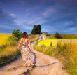 Beautiful white girl walking the road before sunset