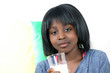 Young african girl holding glass of milk