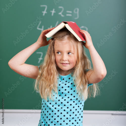 사진:schulmädchen mit buch auf dem kopf schulmädchen mit buch auf dem kopf