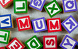 Wooden blocks forming the word MUM in the center Wooden blocks forming the word MUM in the center