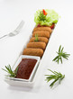 Croquetas y guarnición con salsa.