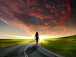 Man walking away at dawn along road