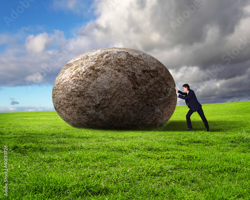 Illustration: Businessman rolling a giant stone Businessman rolling a giant stone