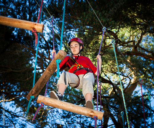 Photo: Girl climbing in adventure park Girl climbing in adventure park