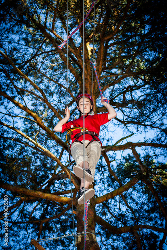 Foto: Girl climbing in adventure park Girl climbing in adventure park