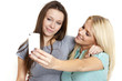 two beautiful woman taking photo a smart phone