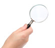 Hand holding a magnifying glass Hand holding a magnifying glass
