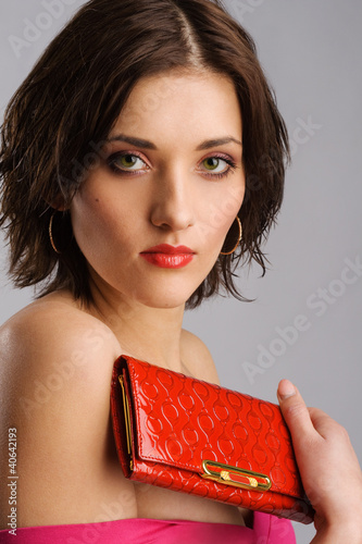Photo: Young beautiful woman with a red purse Young beautiful woman with a red purse