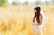 Angel girl in golden field with feather white wings