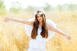 Angel girl in golden field with feather white wings