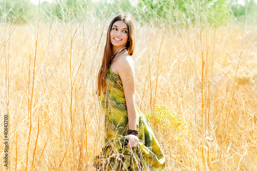 Foto: Asian indian woman walking outdoors in golden field Asian indian woman walking outdoors in golden field