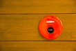 red fire alarm bell set against wood wall red fire alarm bell set against wood wall