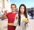 portrait of young friends holding pizza and potato chips at stre portrait of young friends holding pizza and potato chips at stre