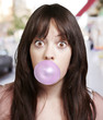 young girl with a pink bubble of chewing gum against a street ba young girl with a pink bubble of chewing gum against a street ba