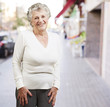 pretty senior woman smiling against a street background pretty senior woman smiling against a street background