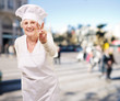 portrait of cook senior woman doing good gesture at crowded stre portrait of cook senior woman doing good gesture at crowded stre