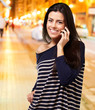 Detalii fotografie Young woman talking on mobile at night city