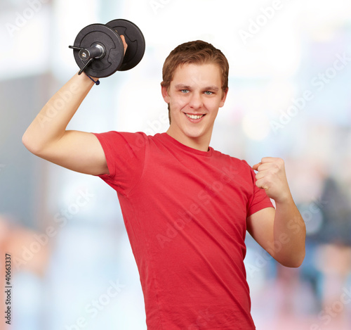 Photo: young man doing fitness with weights indoor young man doing fitness with weights indoor