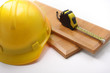 tape measure, hard hat and wooden plank